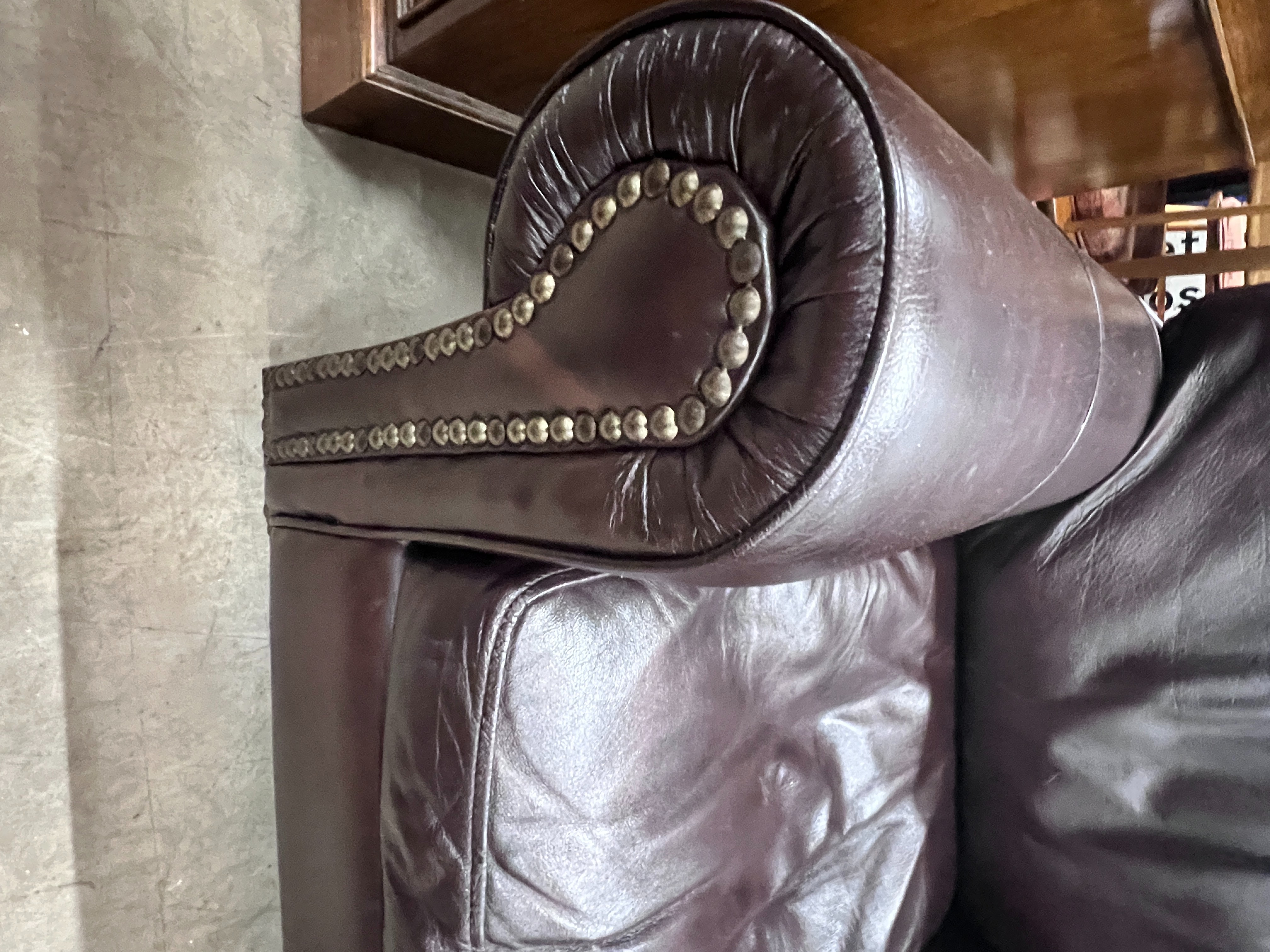 A pair of contemporary studded brown leather armchairs, width 98cm, depth 84cm, height 80cm